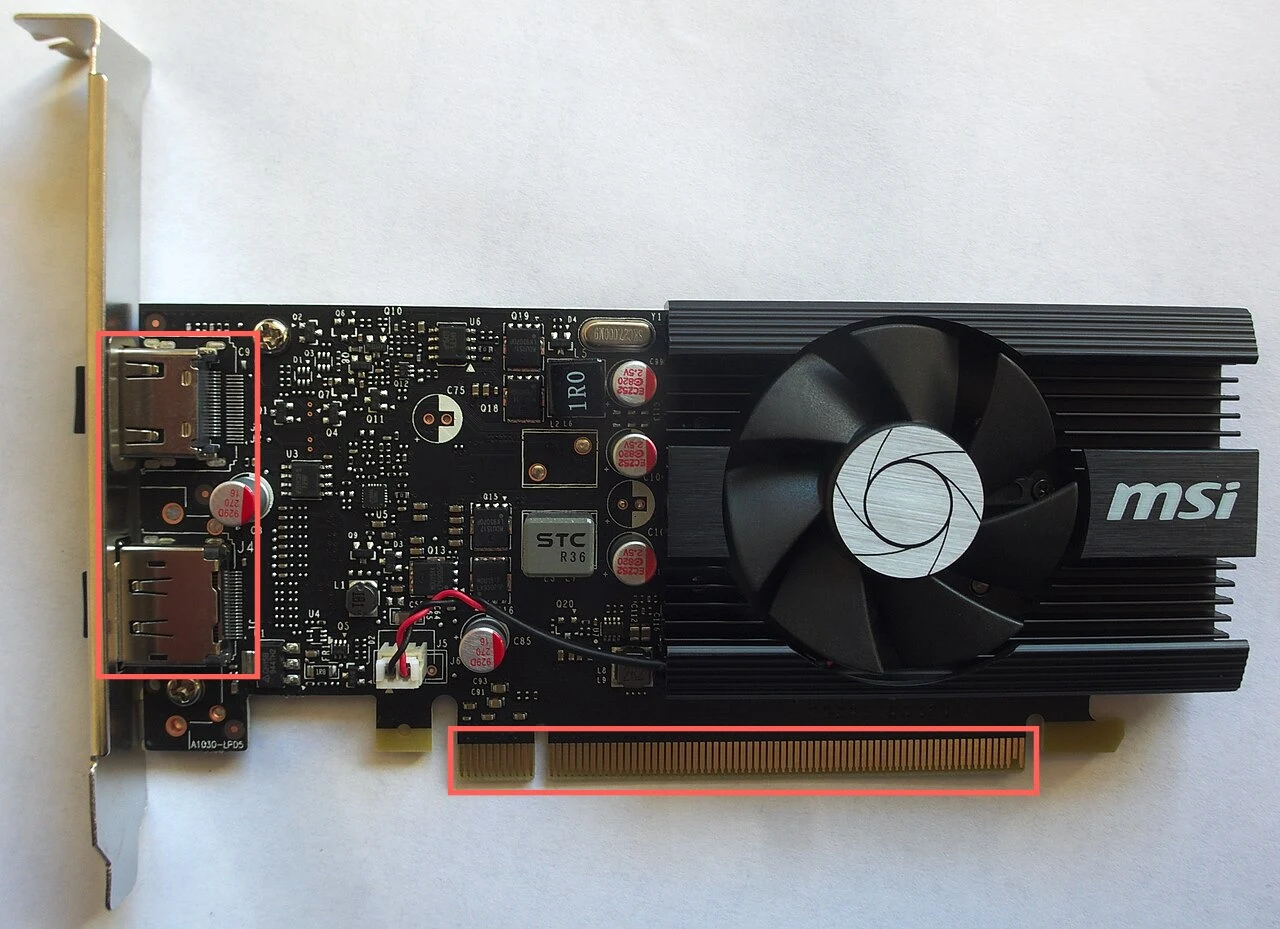 A graphics card lying flat, with a black fan and heatsink on the right and display output ports on a metal bracket at the left. A red box surrounds the two display ports and a second red box surrounds the row of gold contacts along the bottom edge